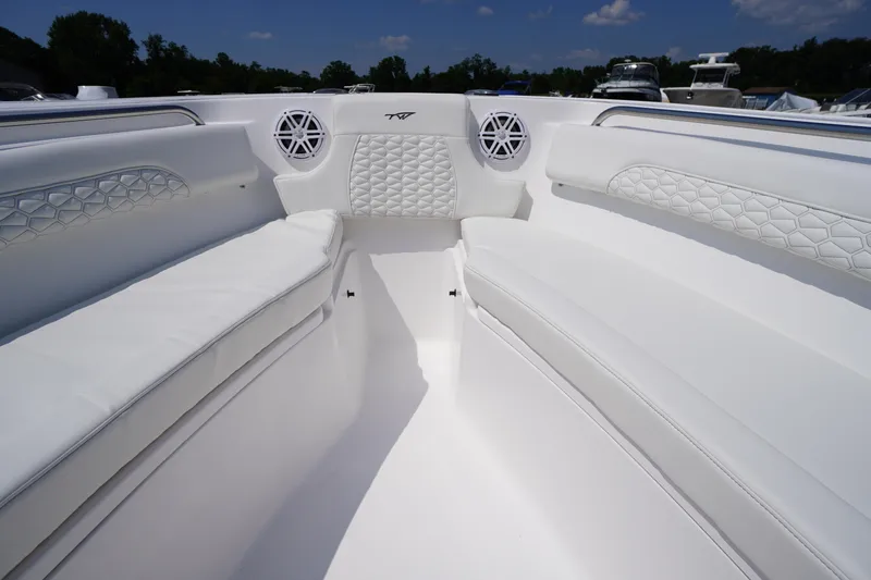 Slide: The Image of 2026 Tidewater 232 CC Adventure boat interior with white cushioned seating and speaker system. - 13