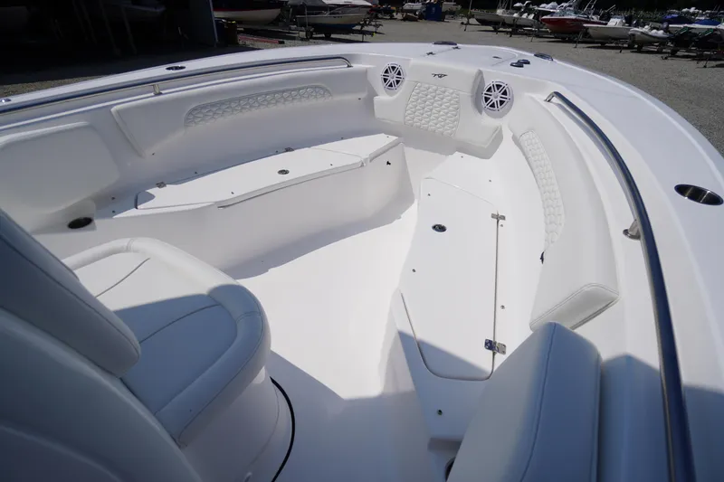 Slide: The Image of 2026 Tidewater 232 CC Adventure boat interior with white seating and storage compartments. - 14