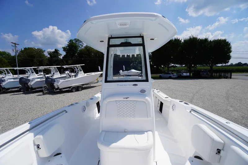 Slide: The Image of 2026 Tidewater 232 CC Adventure boat, white interior, parked outdoors under blue sky. - 21