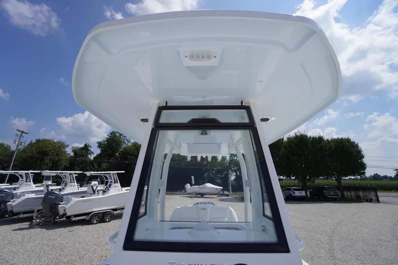 Slide: The Image of 2026 Tidewater 232 CC Adventure boat, viewed from below, showcasing its sleek design under a blue sky. - 22
