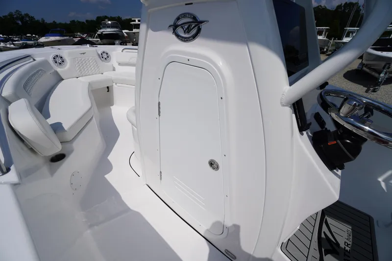 Slide: The Image of 2026 Tidewater 232 CC Adventure boat interior with seating and steering console. - 28