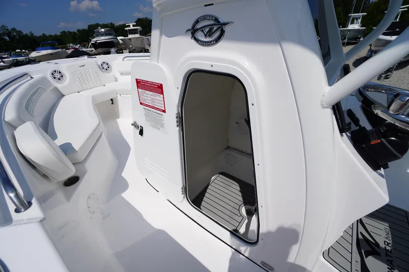 Slide: The Image of 2026 Tidewater 232 CC Adventure boat interior with open cabin door and seating area. - 29