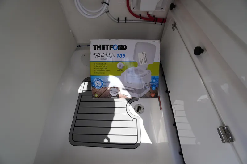 Slide: The Image of Portable toilet in 2026 Tidewater 232 CC Adventure boat storage compartment. - 32