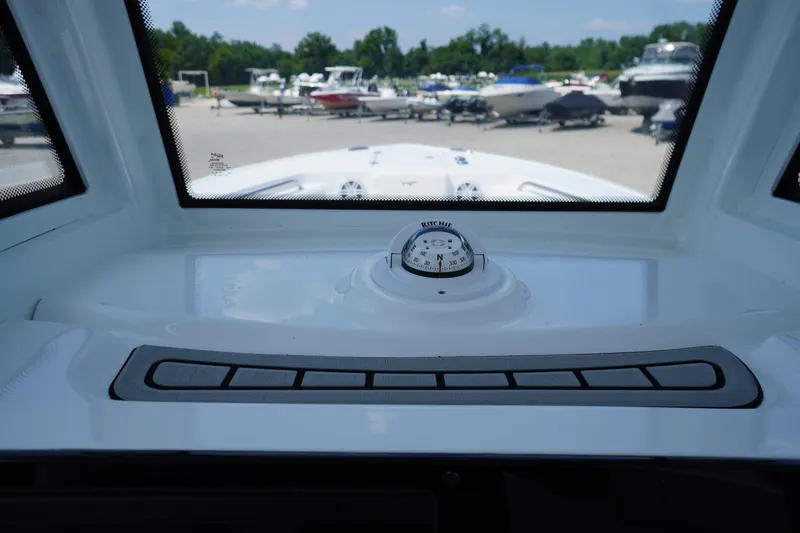 Slide: The Image of 2026 Tidewater 232 CC Adventure boat dashboard with compass and control panel. - 37