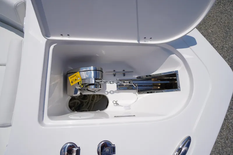 Slide: The Image of Anchor compartment of 2026 Tidewater 232 CC Adventure boat, featuring a winch and chain. - 6