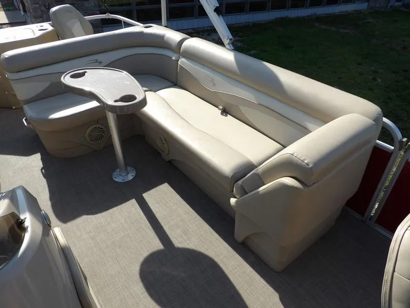 Slide: The Image of 2015 Bennington 20 SFX boat interior with beige seating and a small table. - 12