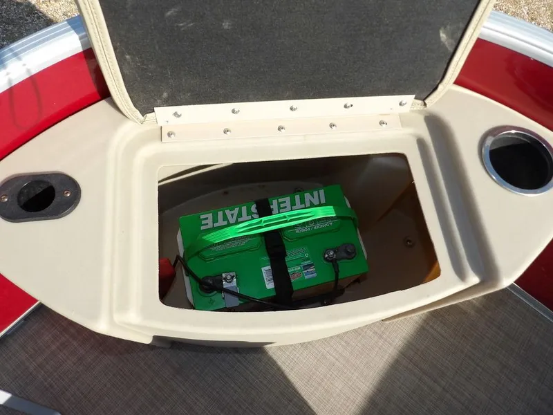 Slide: The Image of Battery compartment of a 2015 Bennington 20 SFX boat, featuring an Interstate battery. - 16