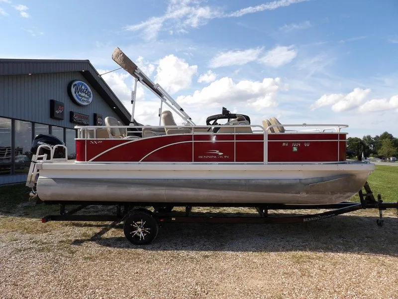 Slide: The Image of 2015 Bennington 20 SFX pontoon boat on trailer, parked outdoors. - 3