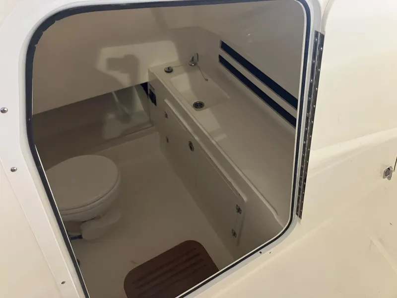 Slide: The Image of 2025 Boston Whaler 330 Outrage interior cabin with toilet and sink. - 12