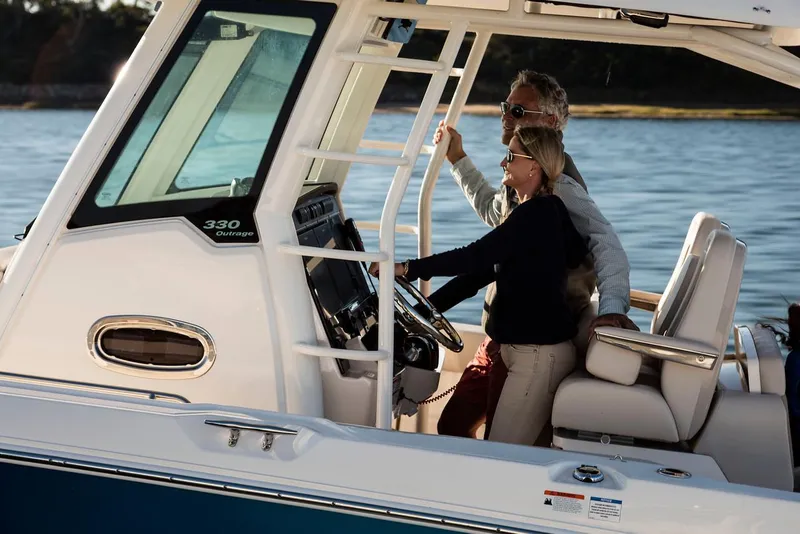 Slide: The Image of Manufacturer Provided Image: Couple enjoying a 2025 Boston Whaler 330 Outrage boat on the water. - 29