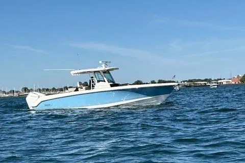 Slide: The Image of 2025 Boston Whaler 330 Outrage boat cruising on open water under clear blue sky. - 35