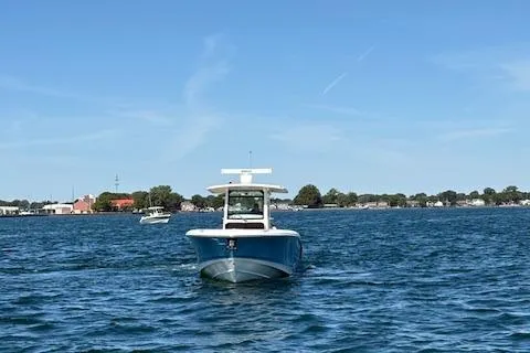 Slide: The Image of 2025 Boston Whaler 330 Outrage boat on open water under clear blue sky. - 39