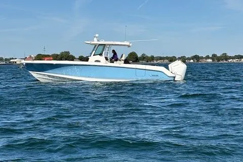 Slide: The Image of 2025 Boston Whaler 330 Outrage boat cruising on open water under clear skies. - 42