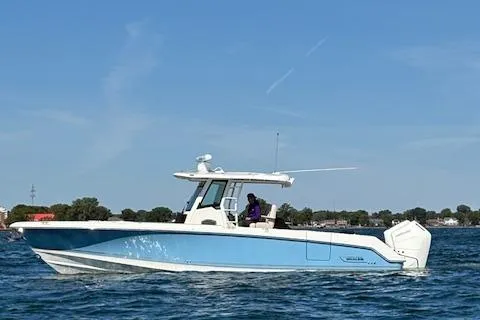 Slide: The Image of 2025 Boston Whaler 330 Outrage boat cruising on a sunny day. - 43