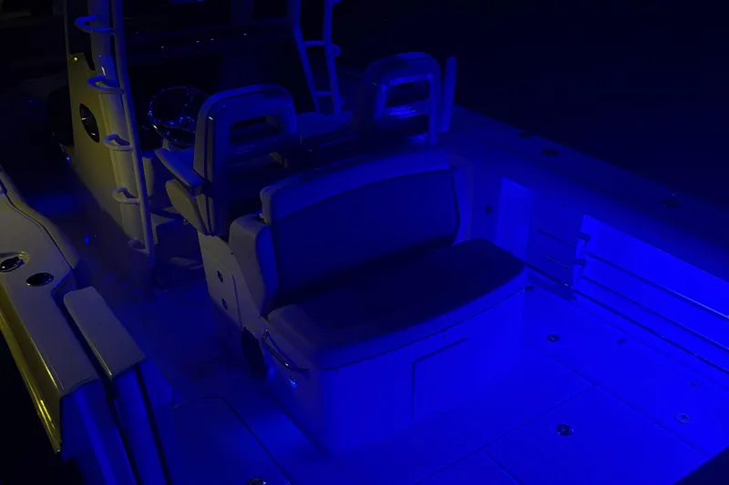 Slide: The Image of 2025 Boston Whaler 330 Outrage interior illuminated with blue lighting. - 47