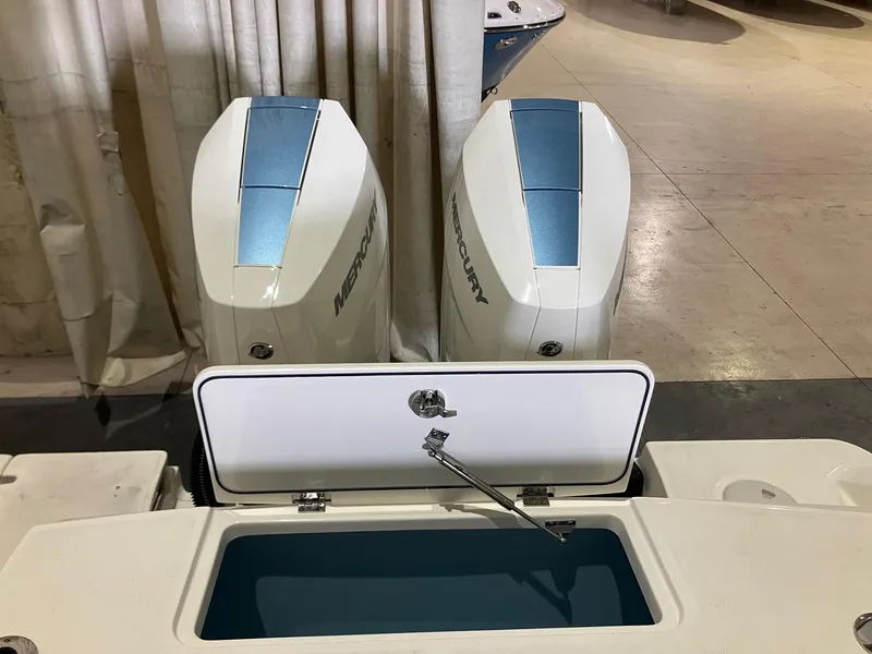 Slide: The Image of 2025 Boston Whaler 330 Outrage with dual Mercury engines and open storage compartment. - 5