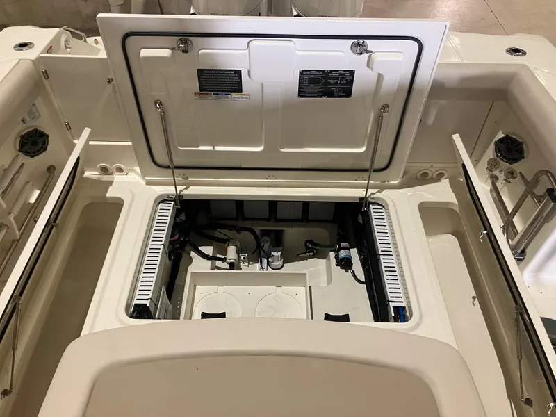 Slide: The Image of 2025 Boston Whaler 330 Outrage boat storage compartment with open hatches and visible equipment. - 7