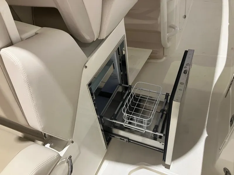 Slide: The Image of 2025 Boston Whaler 330 Outrage interior with open storage compartment and white seating. - 9