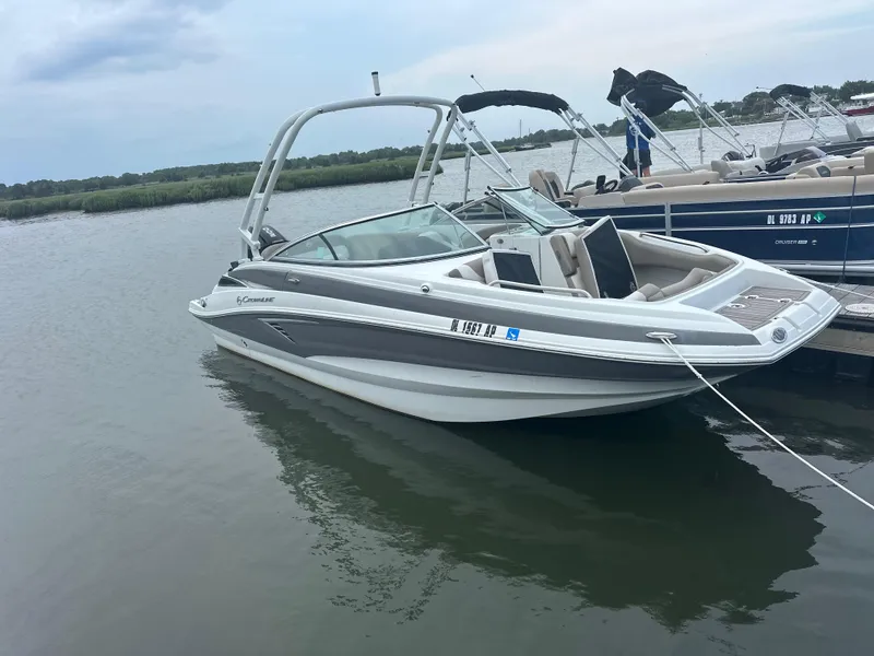 Slide: The Image of 2023 Crownline Eclipse E235 XS boat docked on calm water. - 3