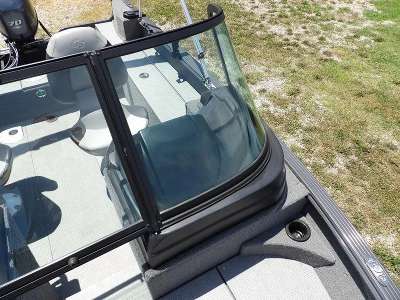 Slide: The Image of 2022 G3 Angler V164 F boat interior with windshield and seating, parked on grass. - 31