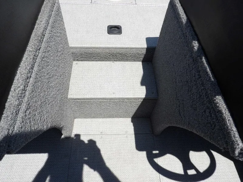 Slide: The Image of 2022 G3 Angler V164 F boat interior with carpeted steps and steering wheel shadow. - 33