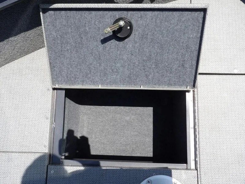 Slide: The Image of Open storage compartment on 2022 G3 Angler V164 F boat, featuring carpeted interior. - 39