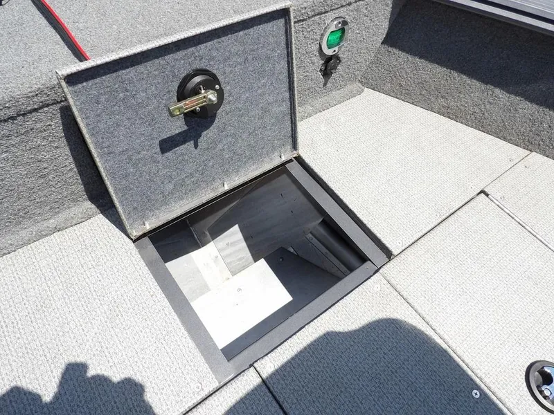 Slide: The Image of 2022 G3 Angler V164 F boat storage compartment with open hatch, gray carpeted interior. - 42
