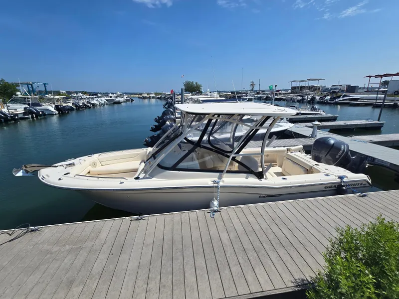 Slide: The Image of 2016 Grady-White Freedom 255 boat docked at marina under clear blue sky. - 0