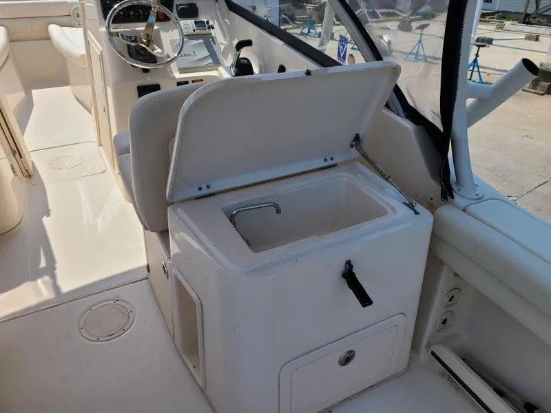 Slide: The Image of 2016 Grady-White Freedom 255 boat interior with open storage compartment and steering wheel. - 10
