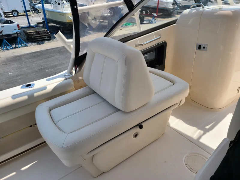 Slide: The Image of 2016 Grady-White Freedom 255 boat interior with white seating and storage compartment. - 13