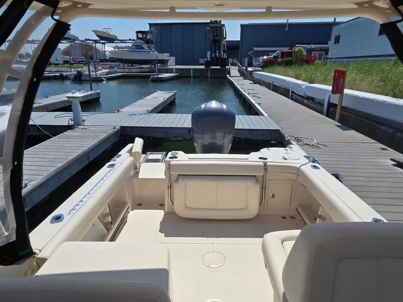 Slide: The Image of 2016 Grady-White Freedom 255 boat docked at a marina, rear view. - 14