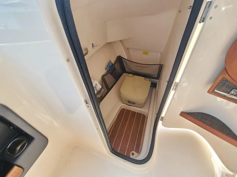Slide: The Image of 2016 Grady-White Freedom 255 boat interior with compact toilet and storage. - 17