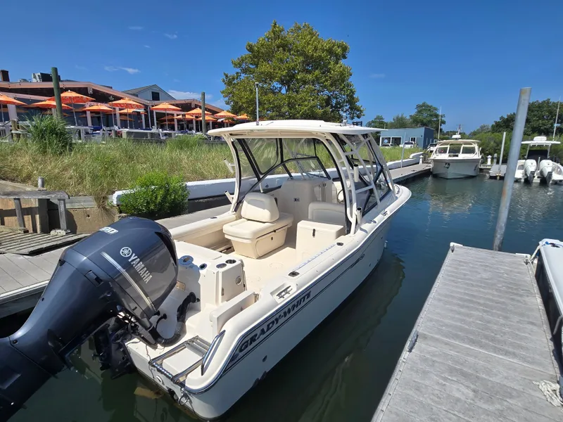 Slide: The Image of 2016 Grady-White Freedom 255 boat docked with Yamaha engine, sunny day, waterfront restaurant nearby. - 20