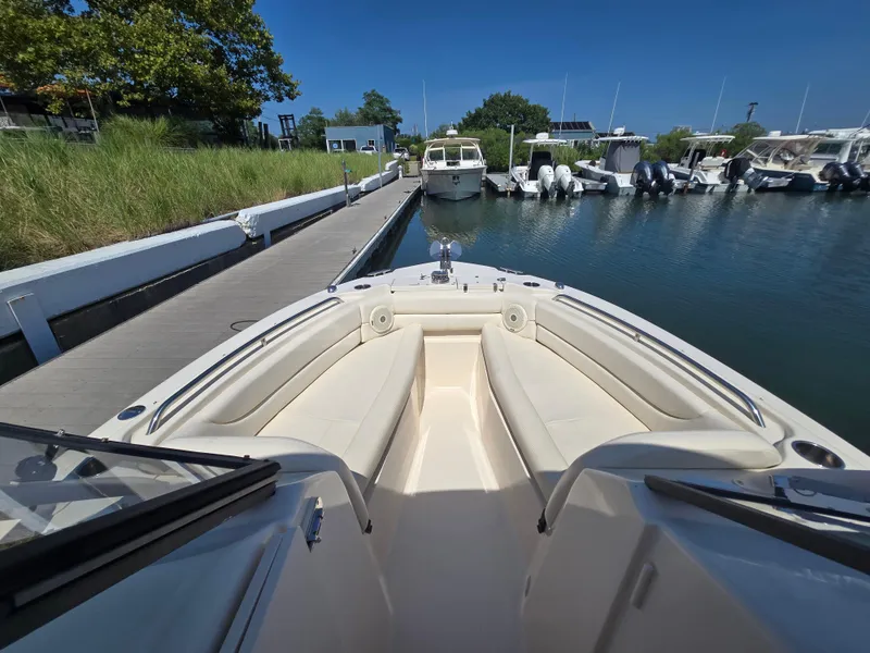 Slide: The Image of 2016 Grady-White Freedom 255 boat docked at marina, featuring spacious seating and clear blue skies. - 5