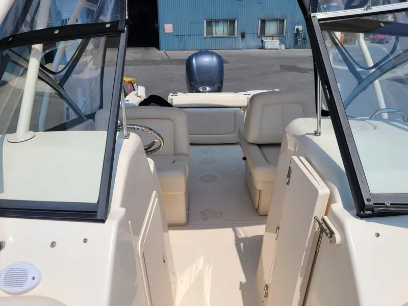 Slide: The Image of 2016 Grady-White Freedom 255 boat interior with seating and windshield, docked at marina. - 6