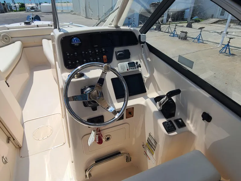 Slide: The Image of 2016 Grady-White Freedom 255 boat cockpit with steering wheel and control panel. - 7