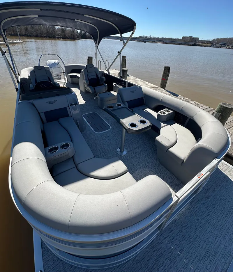 Slide: The Image of 2025 Bennington 23LFB pontoon boat with spacious seating and canopy on a sunny day. - 10