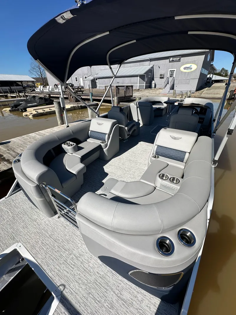 Slide: The Image of 2025 Bennington 23LFB pontoon boat with luxurious seating and canopy at a dock. - 6