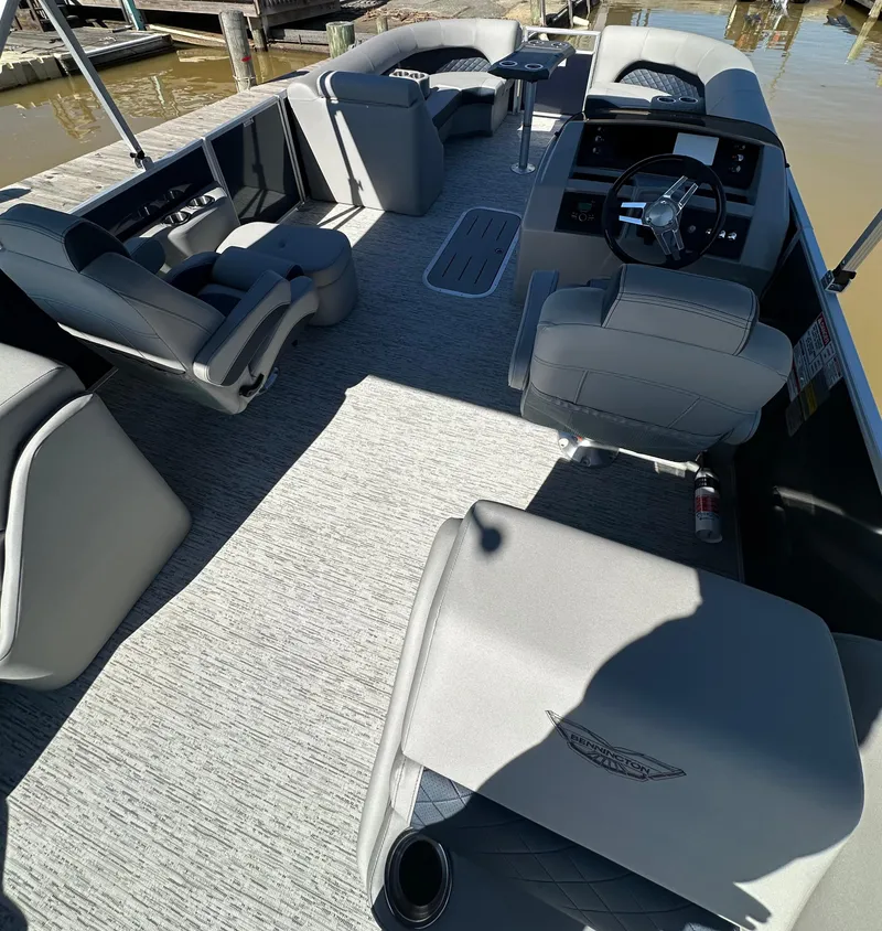 Slide: The Image of 2025 Bennington 23LFB pontoon boat interior with plush seating and modern steering console. - 7