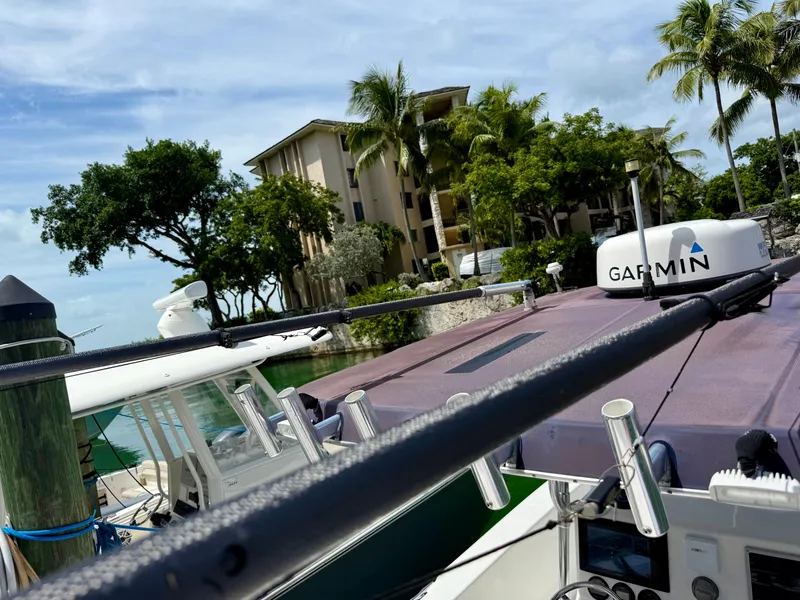 Slide: The Image of 2003 Bluewater Sportfishing 2850 boat docked near tropical trees and buildings. - 16