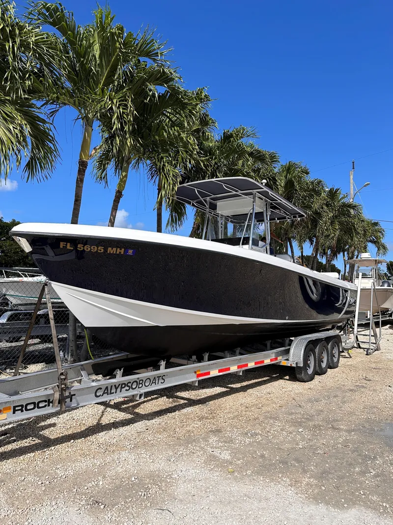 Slide: The Image of 2003 Bluewater Sportfishing 2850 boat on trailer, parked under palm trees. - 23