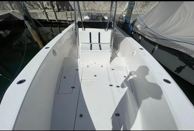 Slide: The Image of 2003 Bluewater Sportfishing 2850 boat interior, spacious deck, clean white finish, docked at marina. - 29