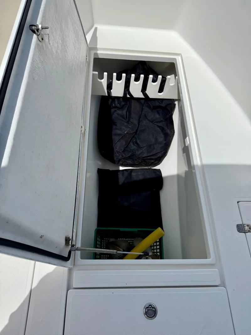 Slide: The Image of Open storage compartment on 2003 Bluewater Sportfishing 2850 boat with bags and equipment. - 6