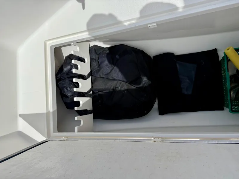 Slide: The Image of Storage compartment in a 2003 Bluewater Sportfishing 2850 boat, containing bags and equipment. - 8