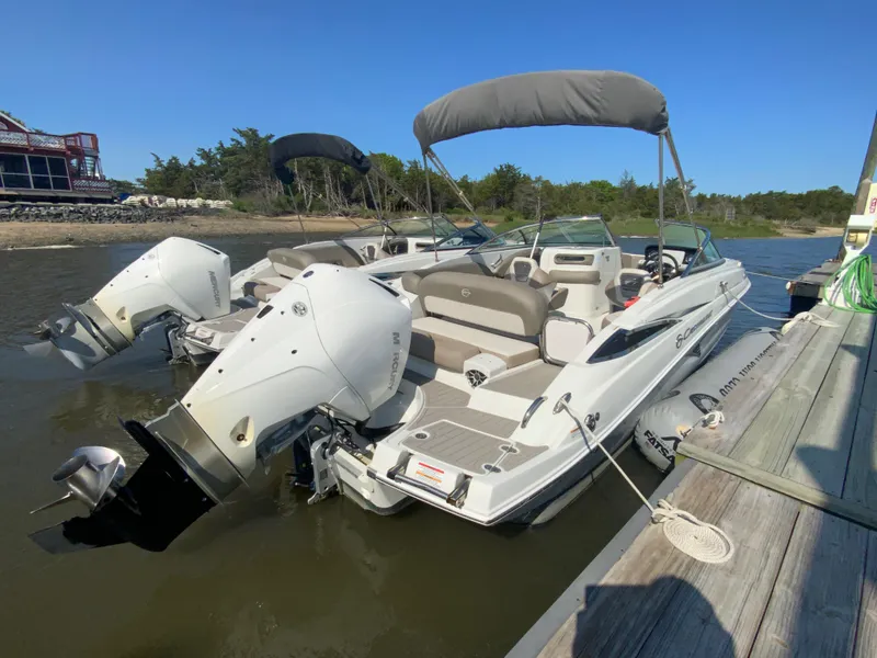 Slide: The Image of 2023 Crownline Eclipse E235 XS boat docked with twin outboard motors. - 3