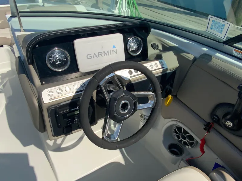 Slide: The Image of 2023 Crownline Eclipse E235 XS boat dashboard with Garmin display and steering wheel. - 5