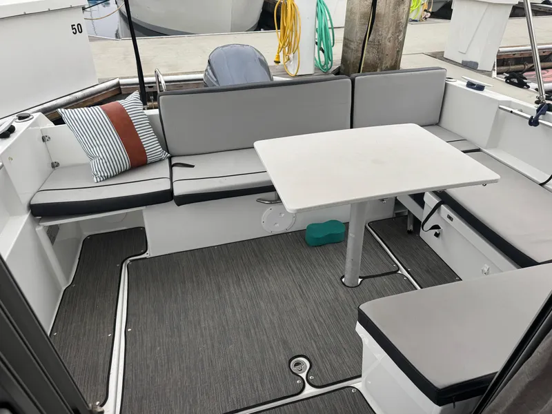 Slide: The Image of 2020 Jeanneau NC Sport 795 boat interior with seating and table, docked at marina. - 21