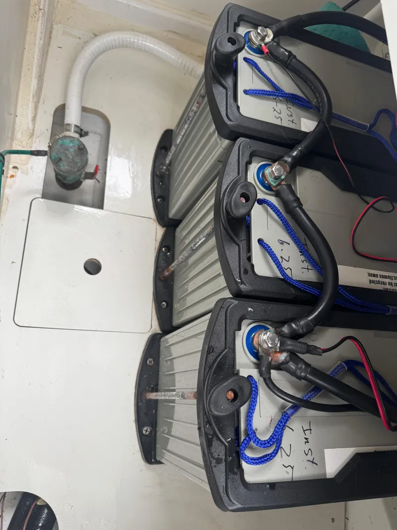 Slide: The Image of Battery compartment of a 2020 Jeanneau NC Sport 795 boat, showing three connected batteries. - 26