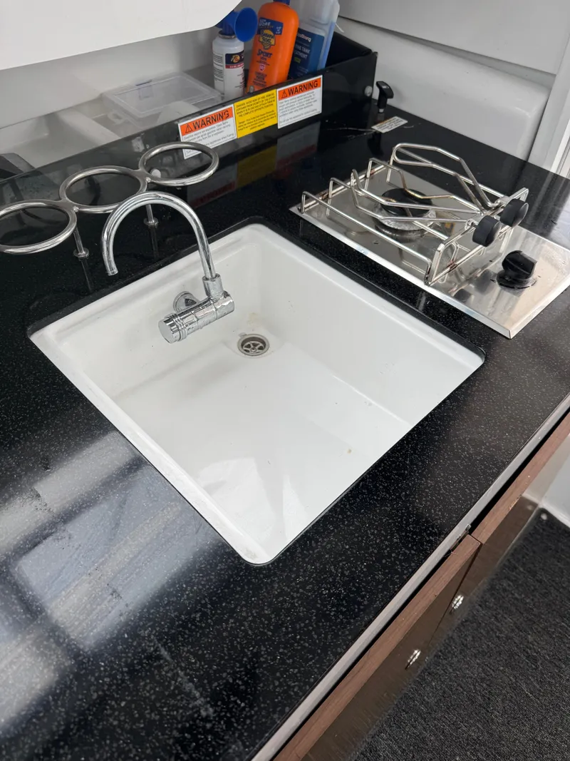 Slide: The Image of Compact kitchen area in 2020 Jeanneau NC Sport 795 with sink and stove. - 31