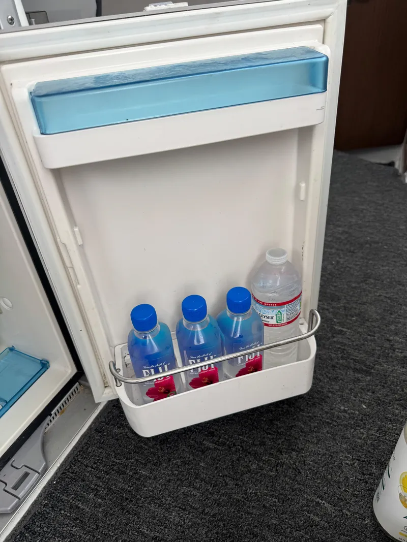 Slide: The Image of Open fridge door on Jeanneau NC Sport 795, showing bottled water storage. - 33